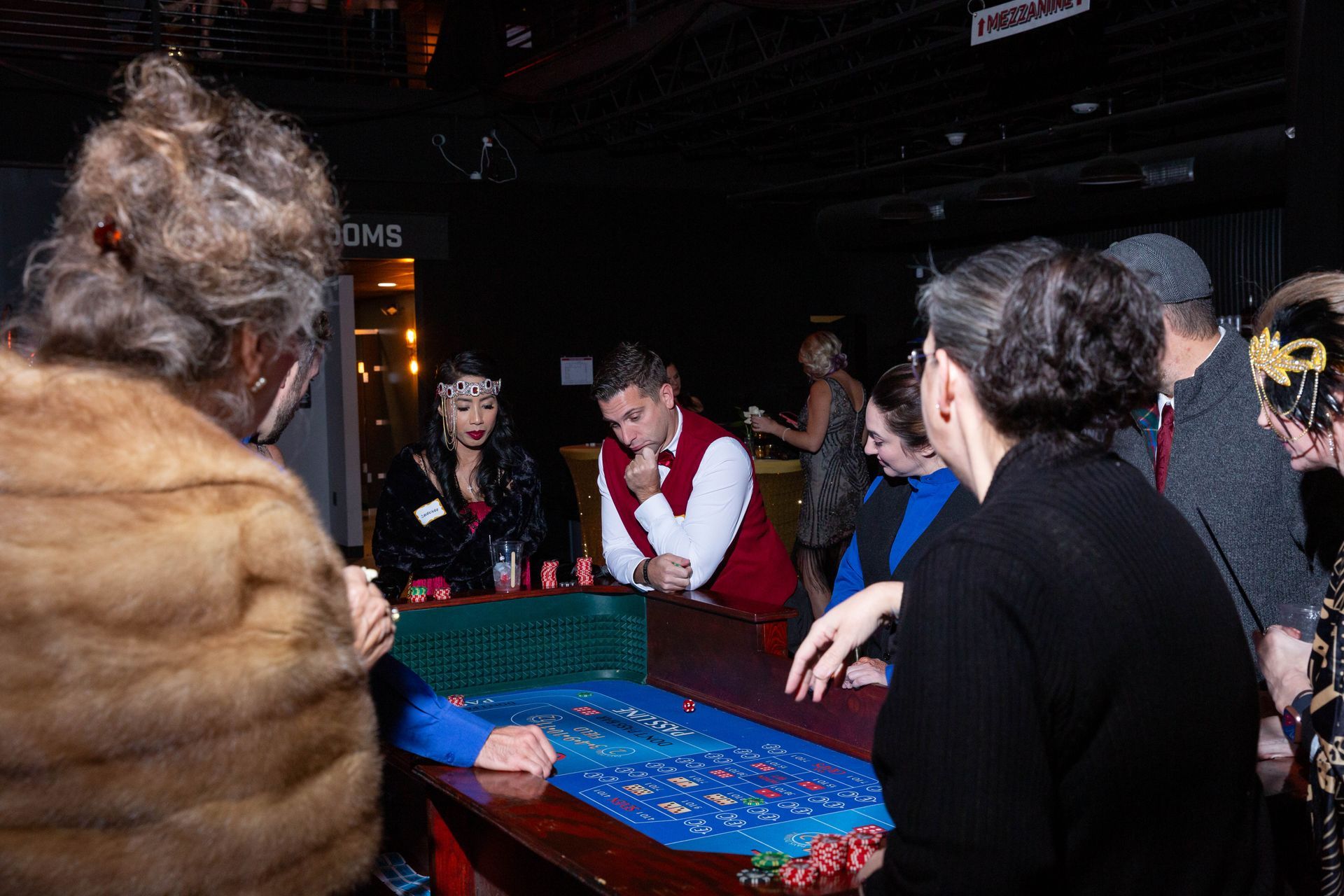 A group of people are sitting at a table playing roulette.