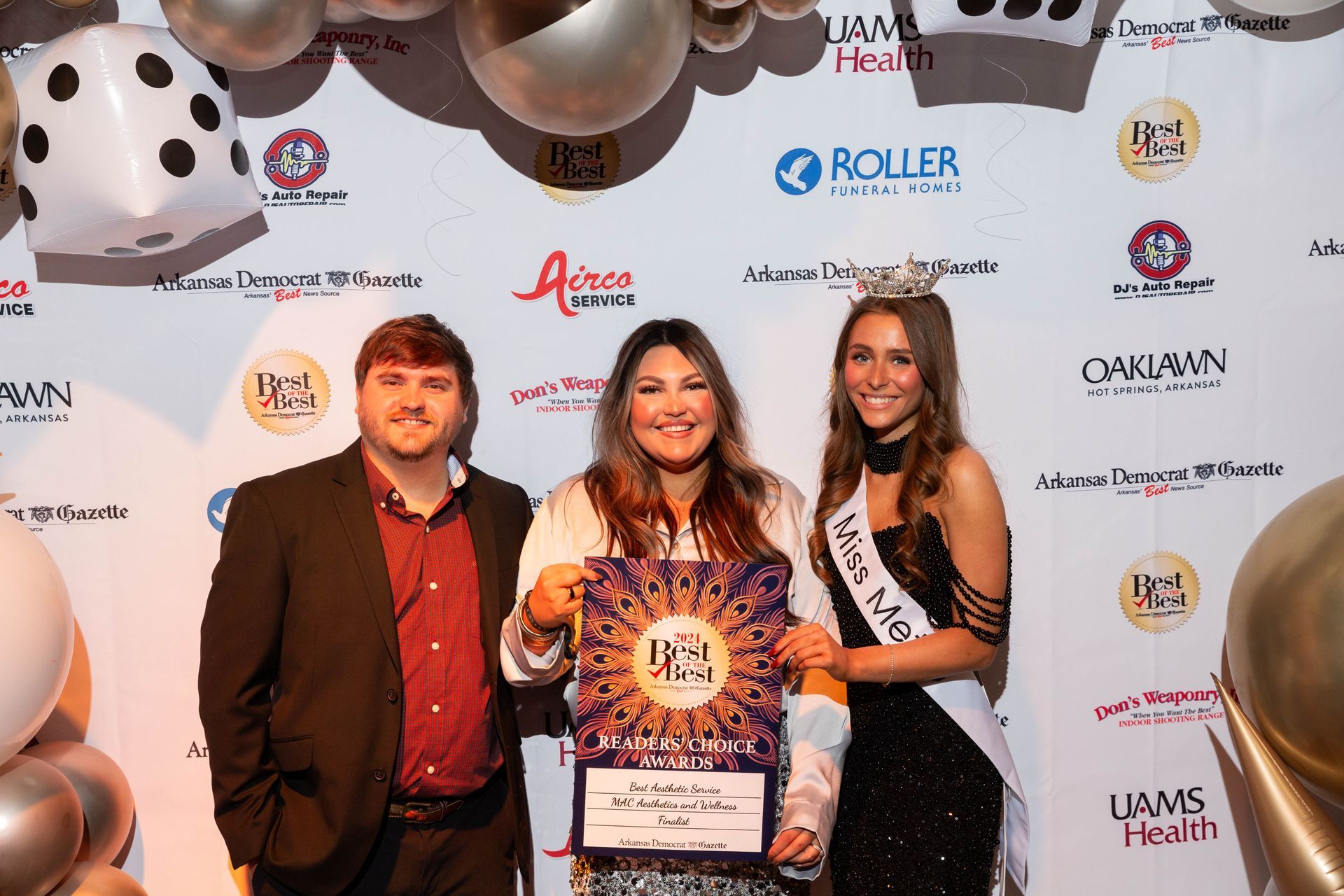 A group of people standing in front of a wall with balloons and dice.