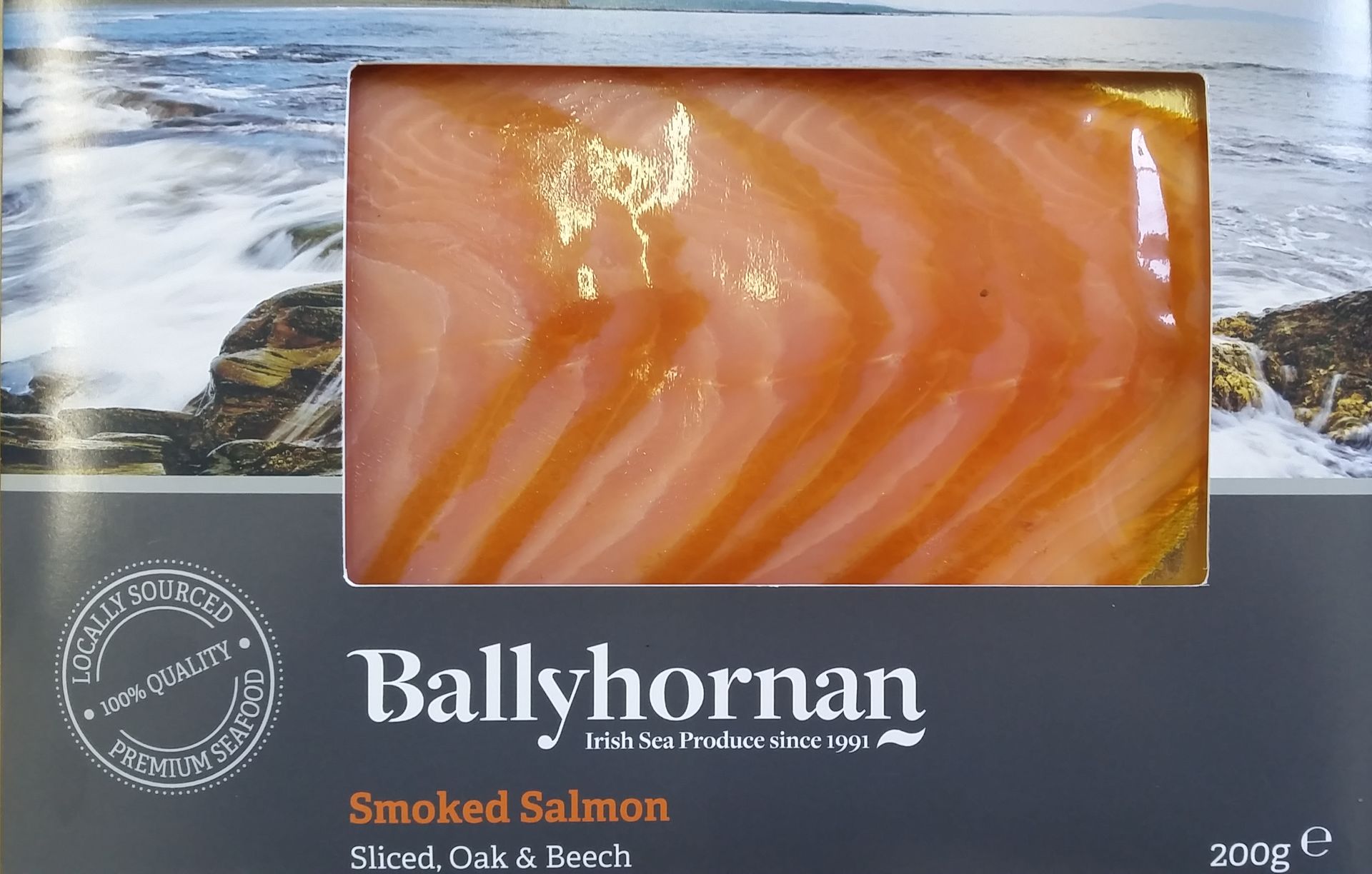 Click for more ... Ballyhornan smoked salmon package. Rectangular tray of orange salmon slices, over a gray box.