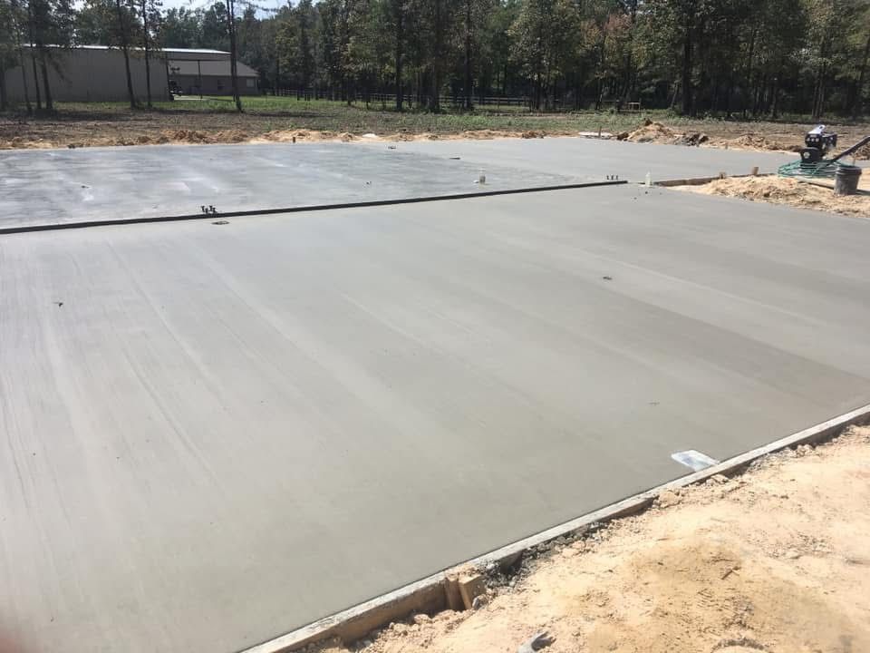 A concrete floor is being poured on a construction site.