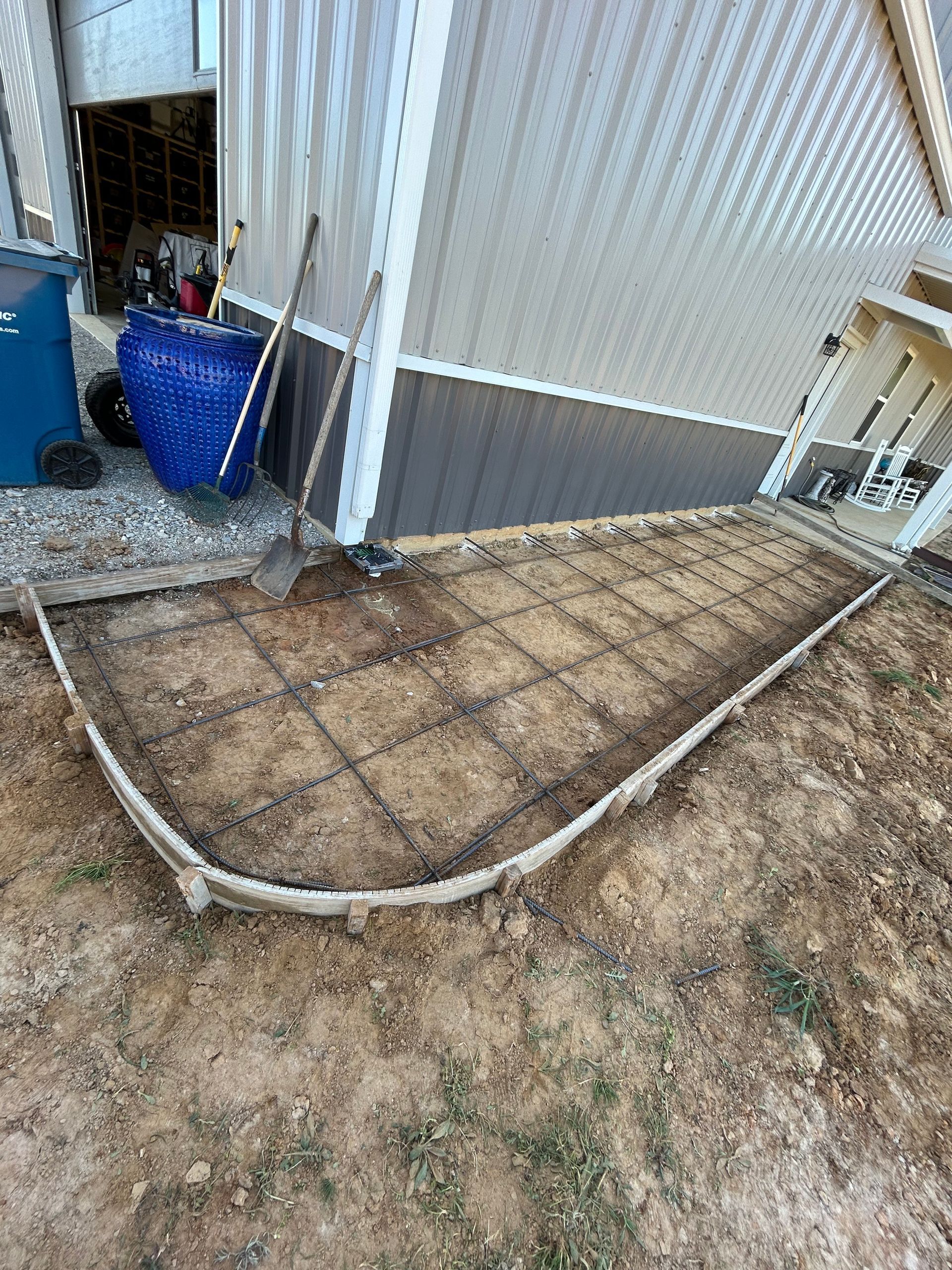 A concrete walkway is being built in front of a house.