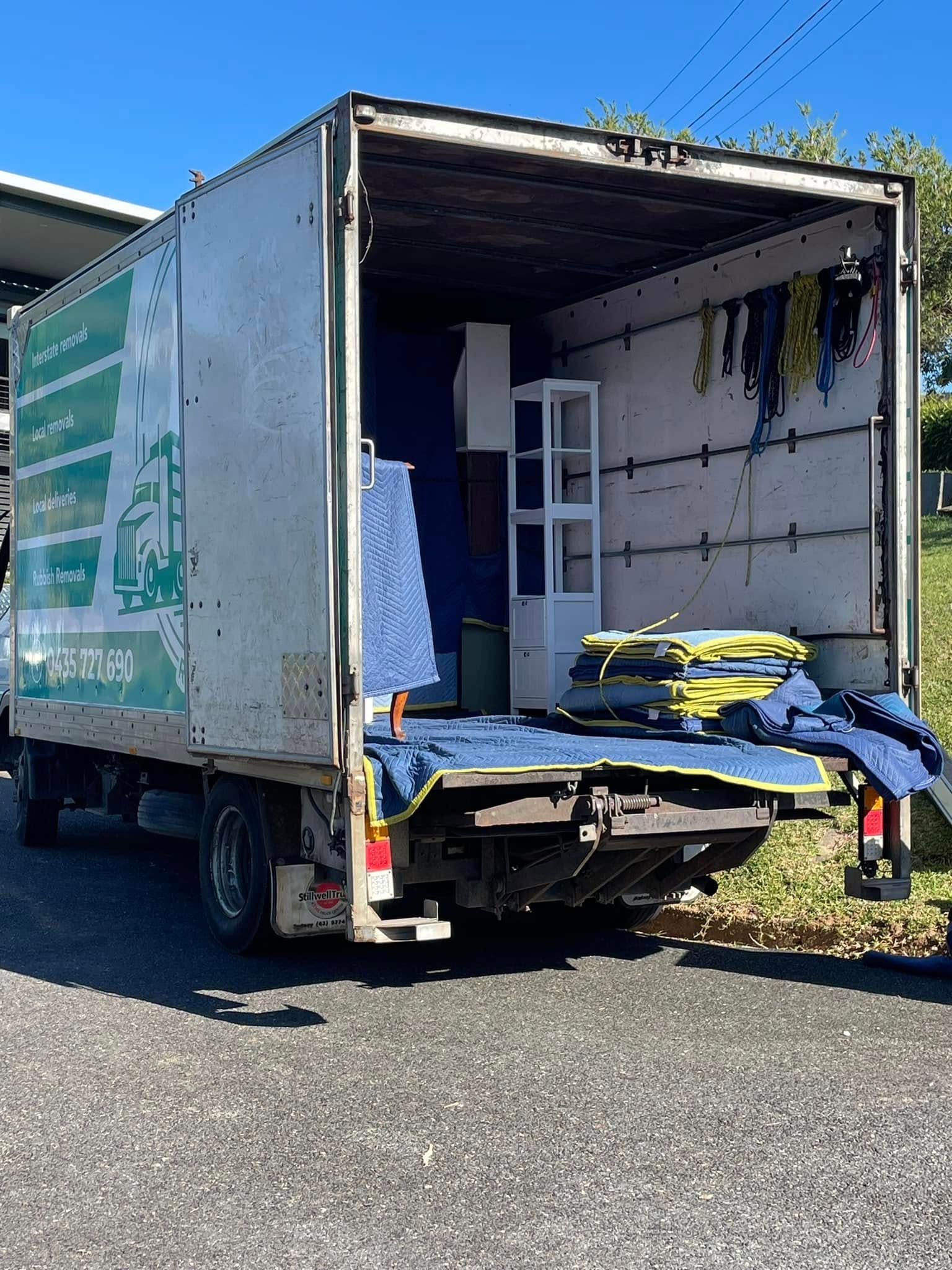 Open moving truck with rear cargo door down, showing stacked furniture and boxes inside — Easy Flow Removals In Port Macquarie, NSW