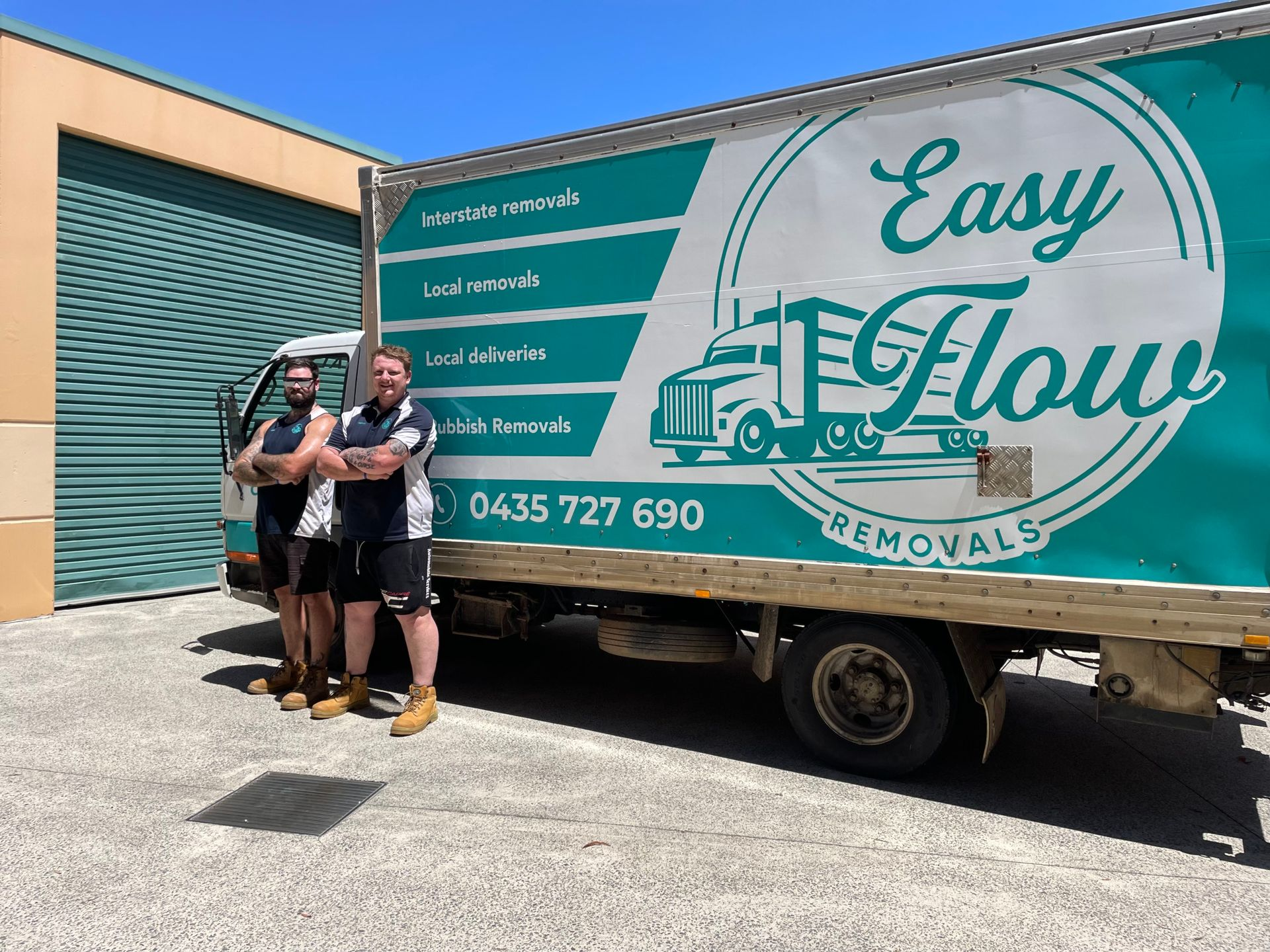 Removalist standing next to a green and white moving truck in Port Macquarie.