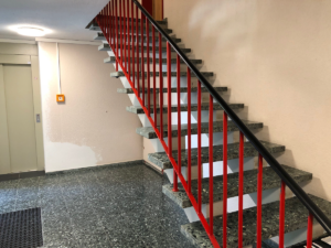 Eine Treppe mit einem roten Geländer in einem Gebäude