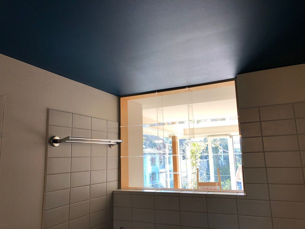 Ein Badezimmer mit blauer Decke und einem Fenster
