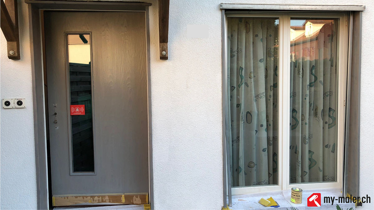 Ein weisses Gebäude mit einer Tür und einem Fenster