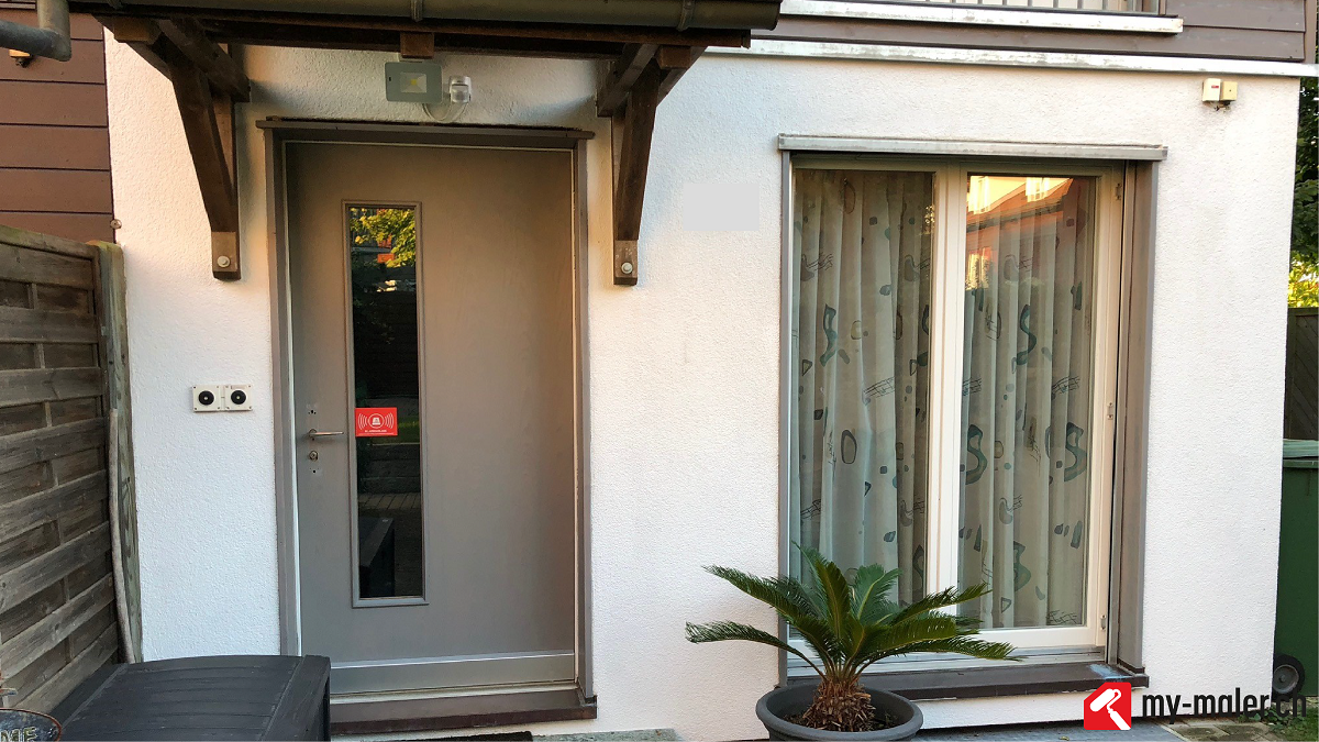 Ein kleines weisses Haus mit einer Tür und einem Fenster.