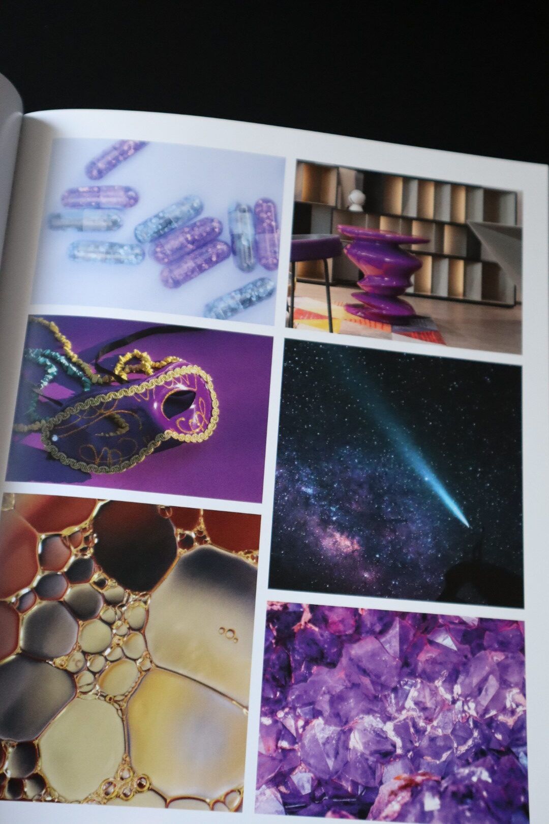 Ein Buch ist auf einer Seite aufgeschlagen, auf der sich violette Bilder befinden