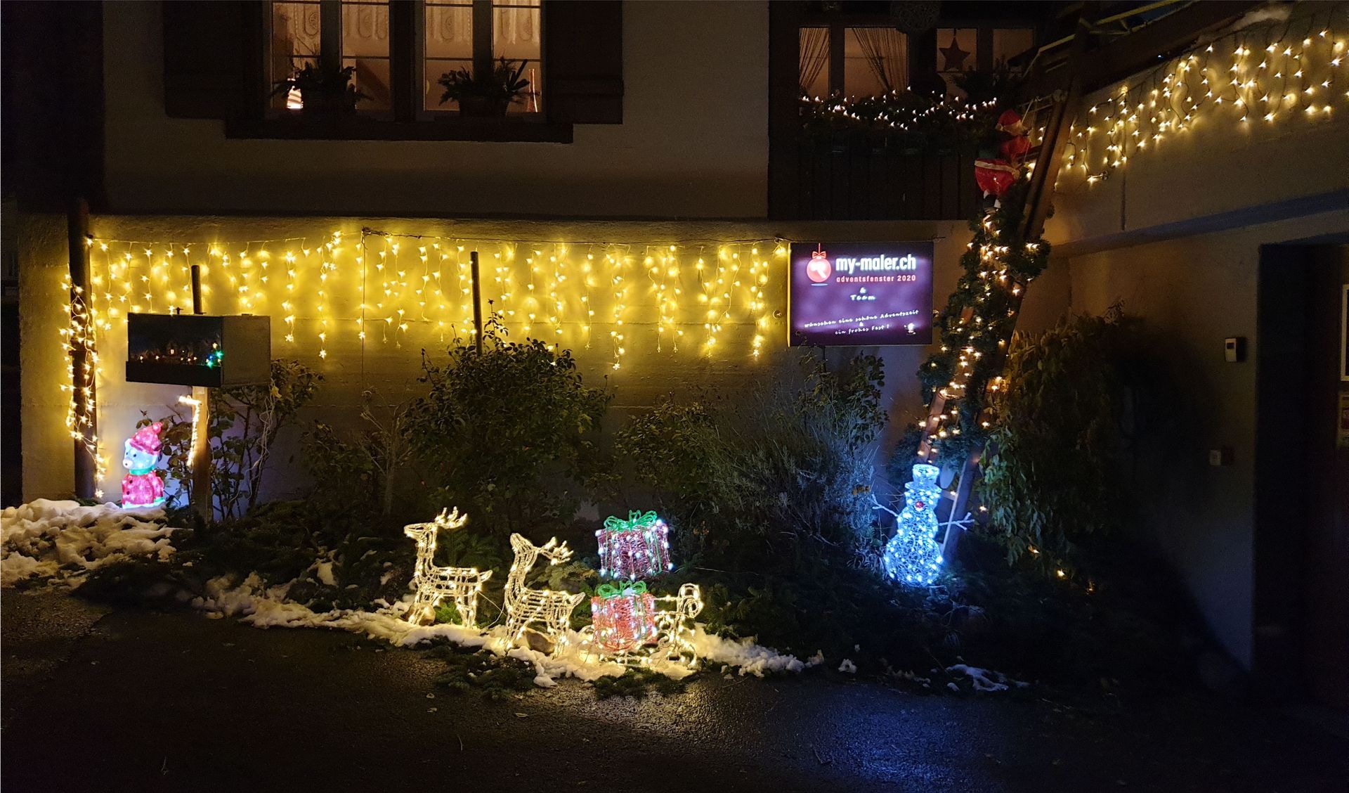 Ein Haus ist nachts mit Weihnachtslichtern geschmückt.