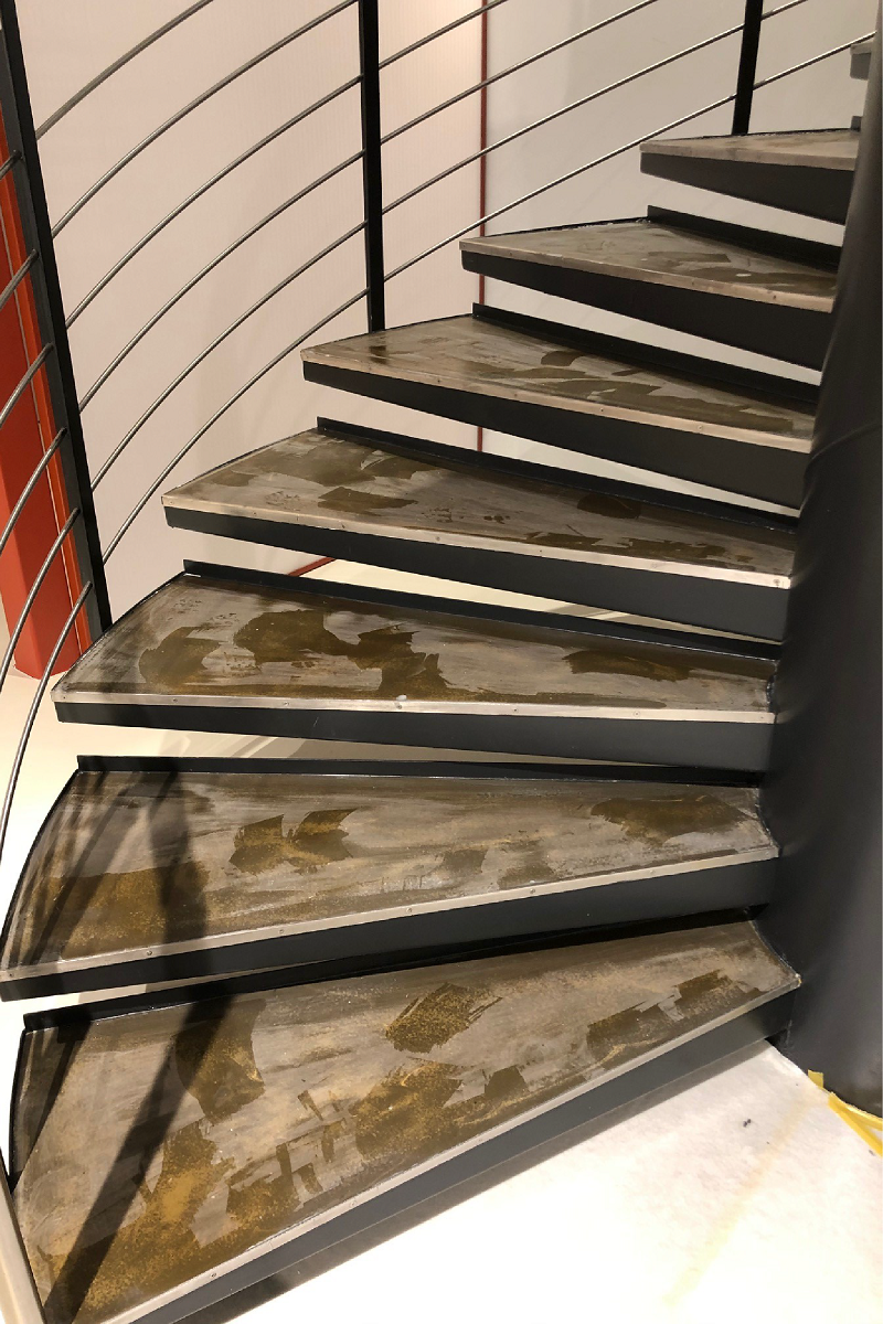 Eine Nahaufnahme einer Wendeltreppe mit Metallgeländer.