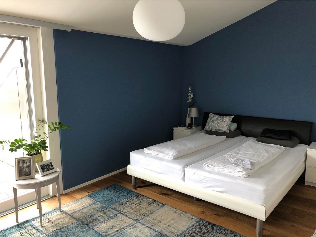 Ein Schlafzimmer mit zwei Betten und einer blauen Wand