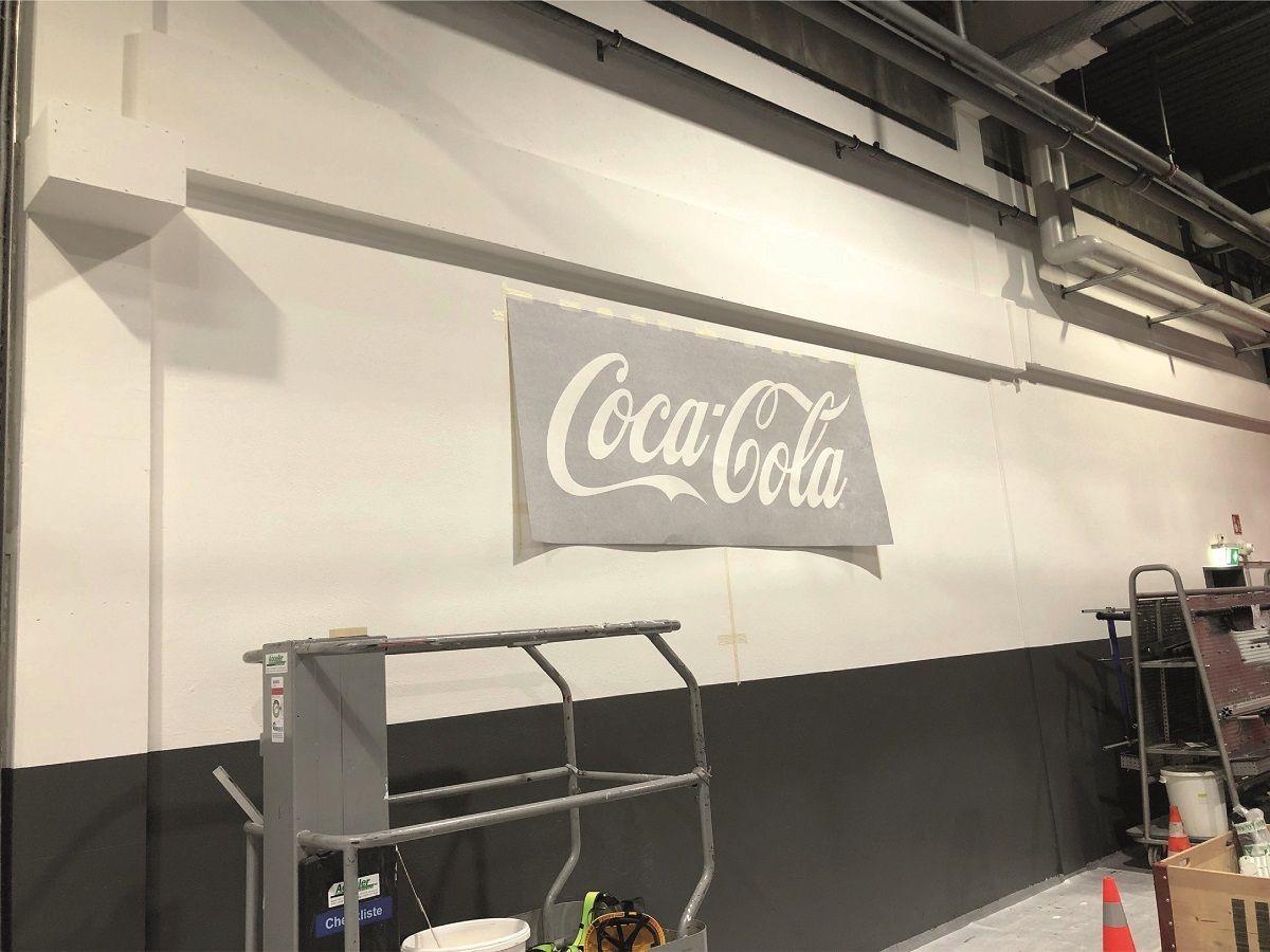 Ein Coca-Cola-Schild ist an die Wand eines Gebäudes gemalt