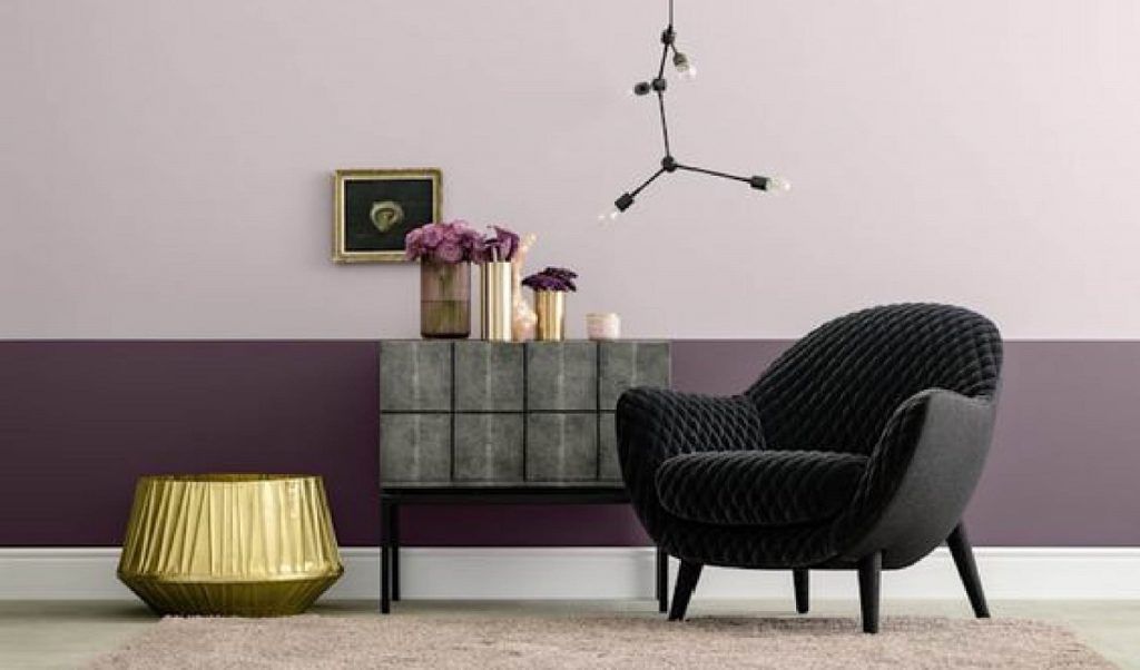 Ein Wohnzimmer mit einem schwarzen Stuhl und einer violetten Wand.