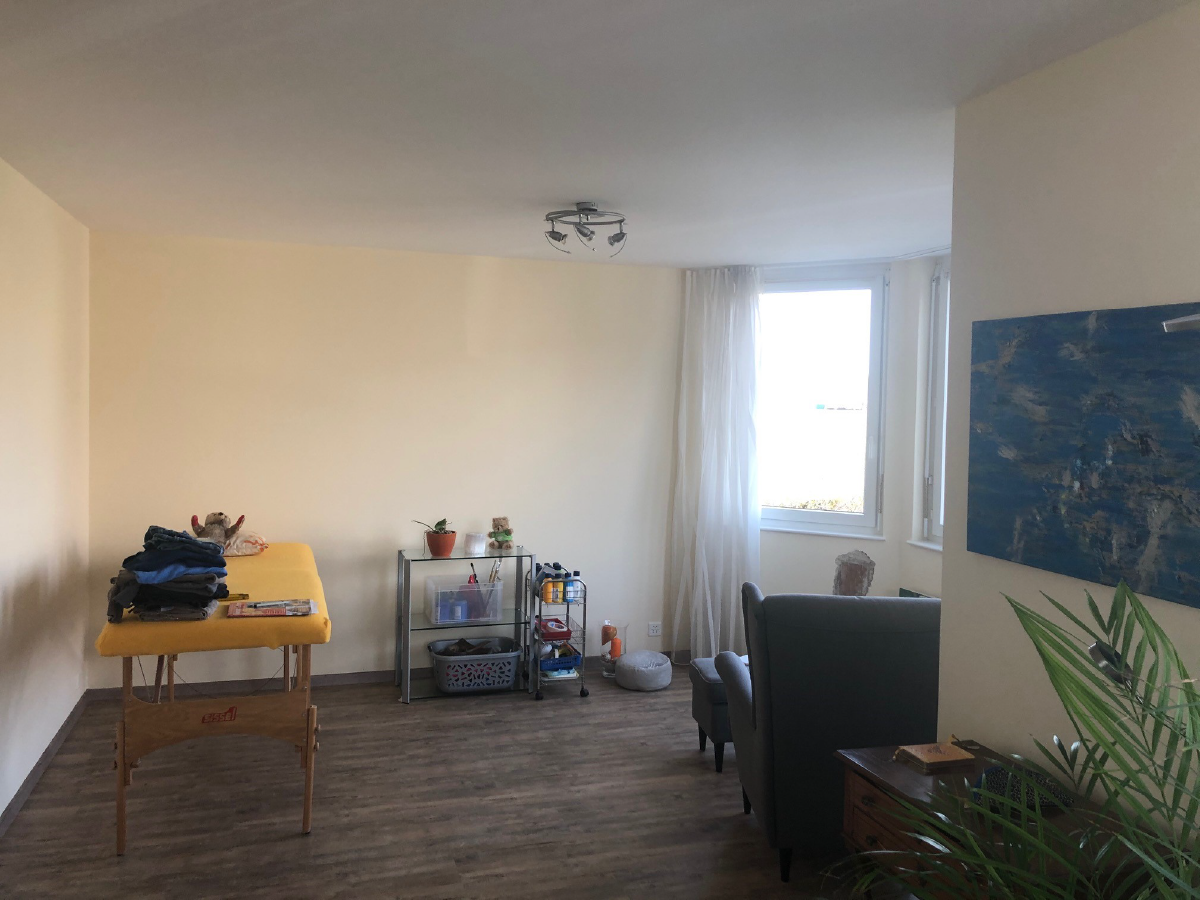 Ein Raum mit einem gelben Tisch und einem blauen Gemälde an der Wand