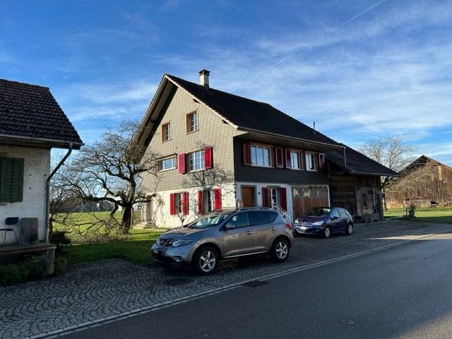 Ein Auto ist vor einem Haus am Strassenrand geparkt.
