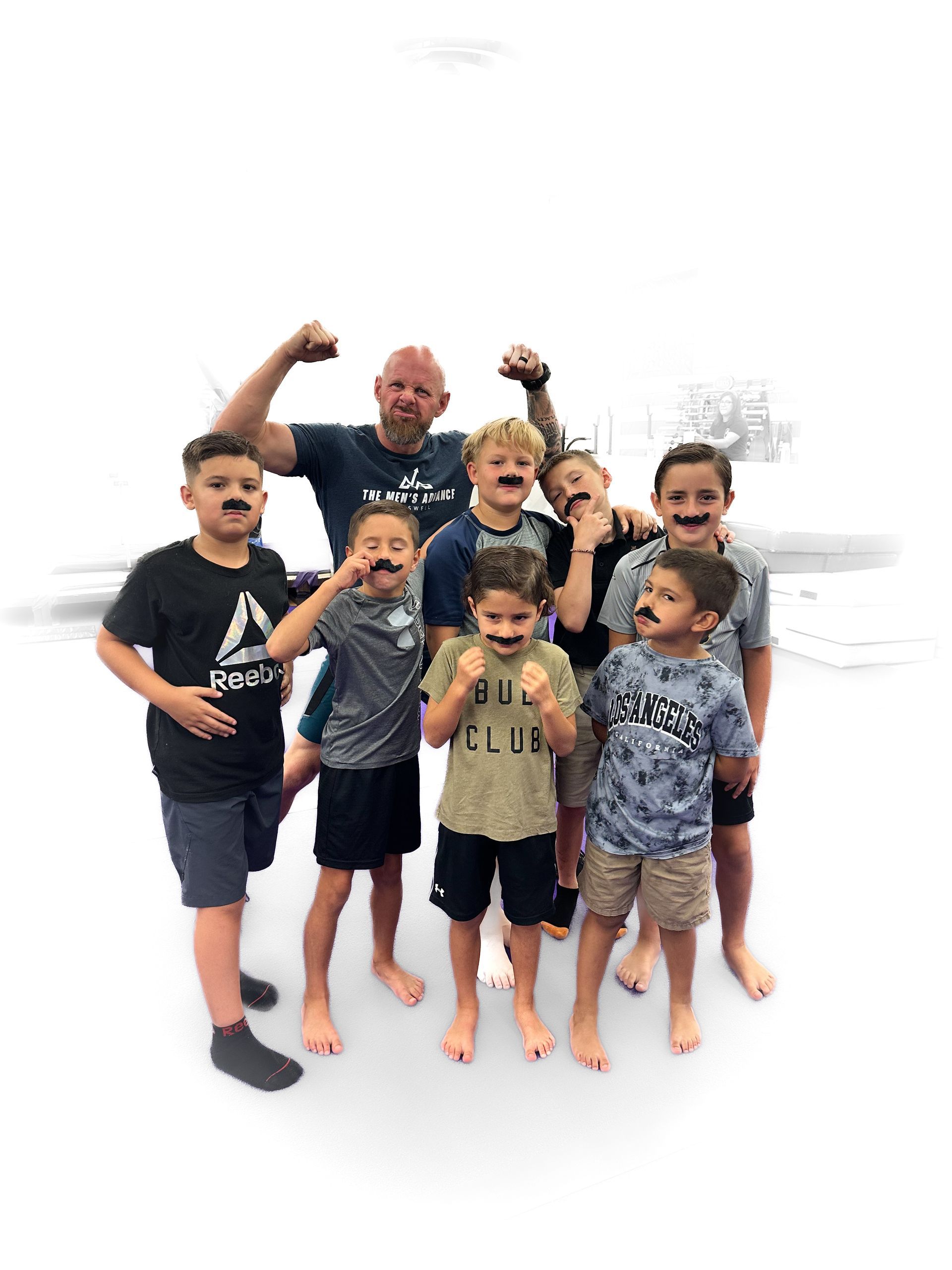 A group of young boys and a man are posing for a picture.