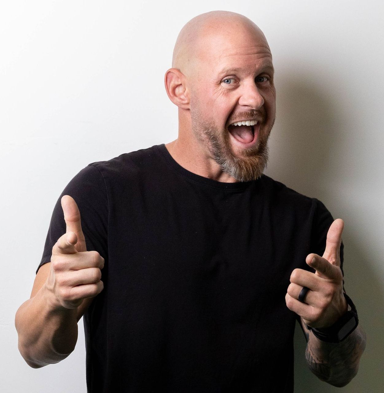 A bald man with a beard is smiling for the camera.