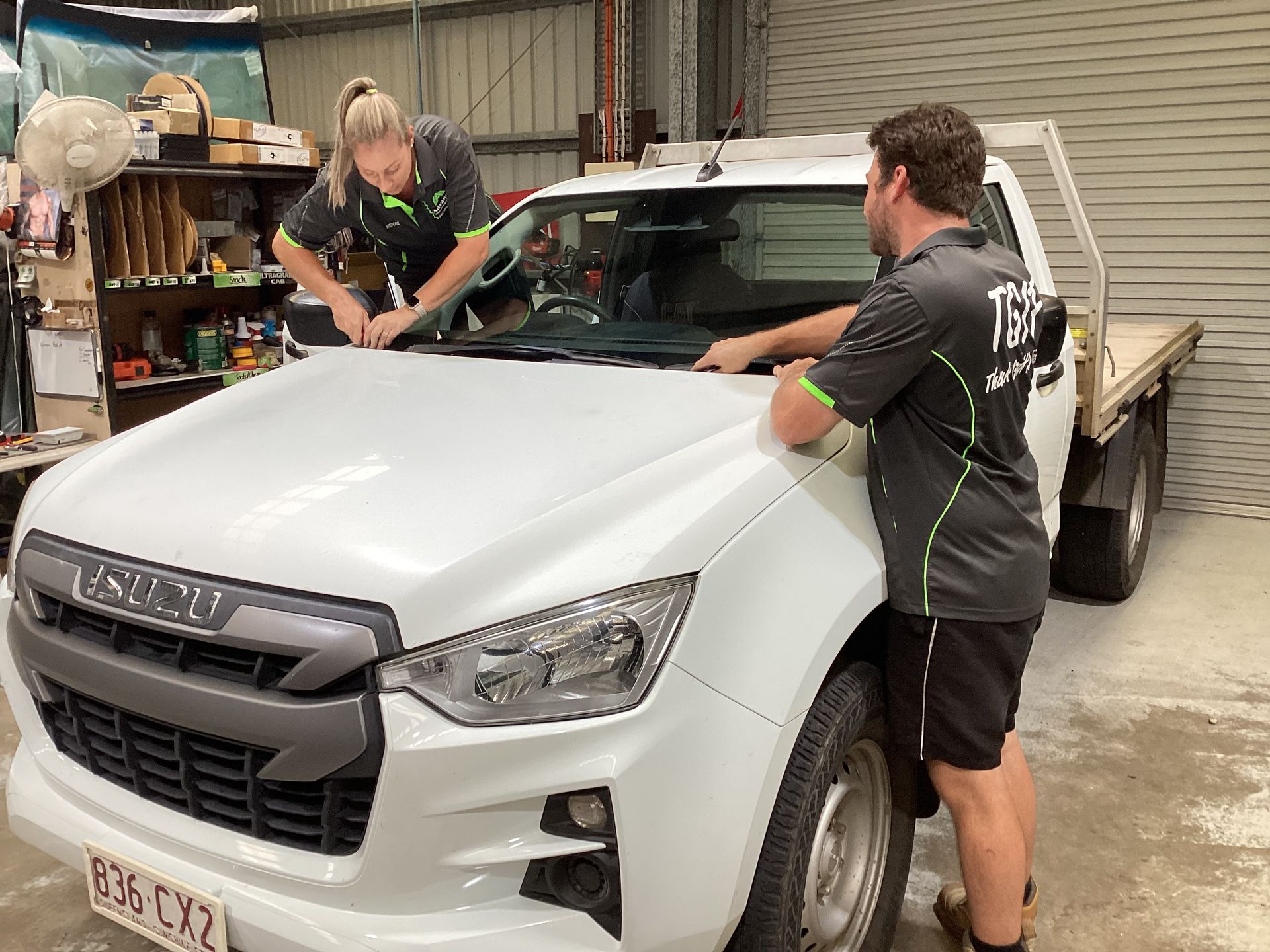 A Man And A Woman Are Putting In A Windscreen— Advanced Windscreens & Service Centre In Airlie Beach, QLD