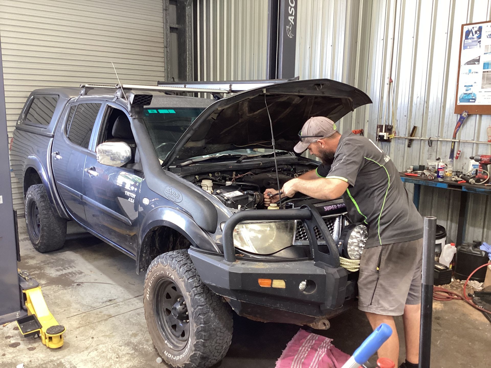 A  Car With The Hood Up With A Man Working on it In A Garage — Advanced Windscreens & Service Centre In Proserpine, QLD