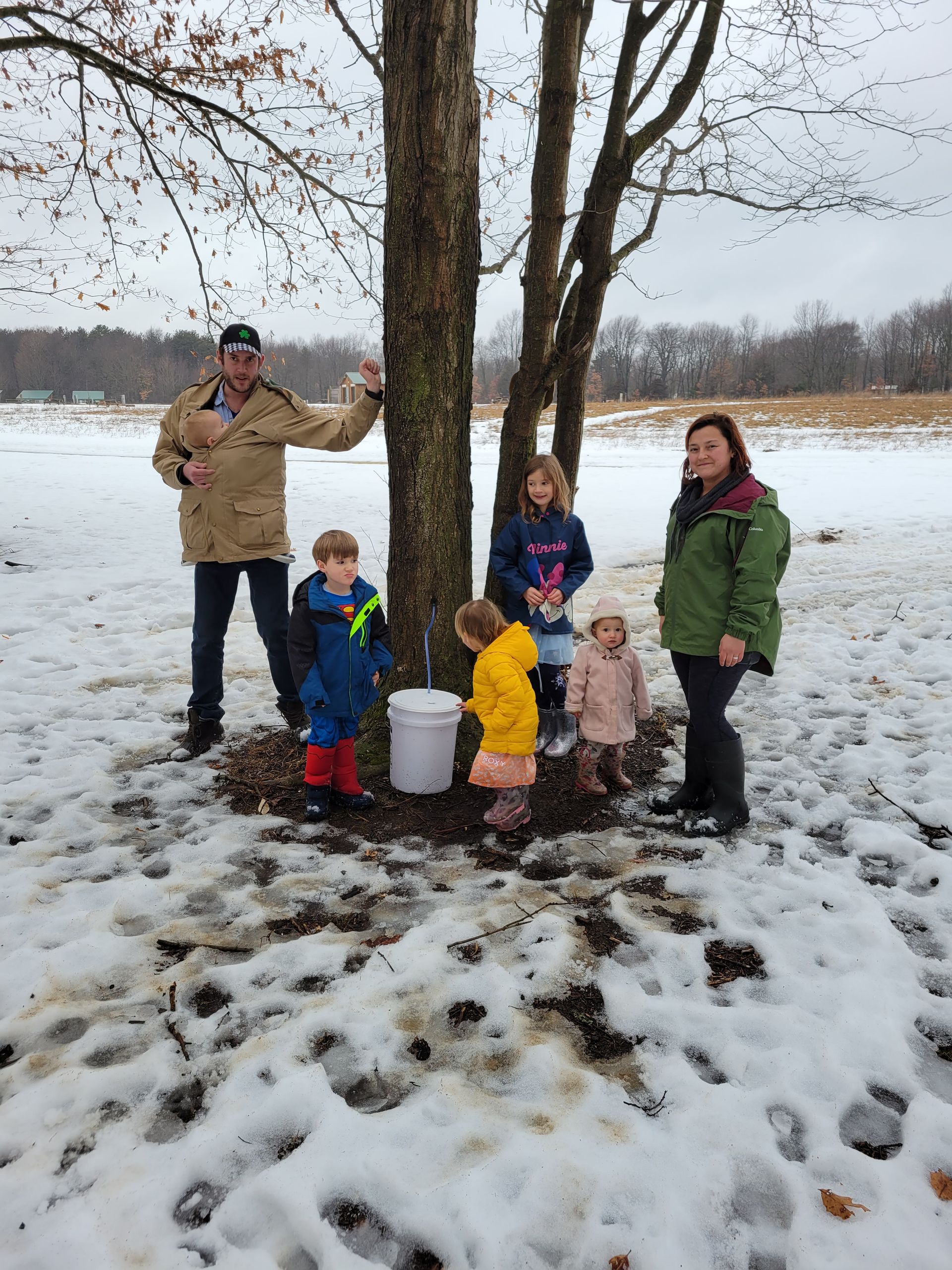 Owners and their kids tapping maple trees for syrup.