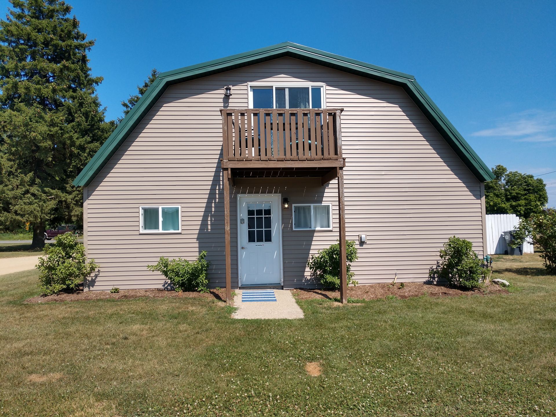 Front view of our duplex west, a former horse barn, with balcony .