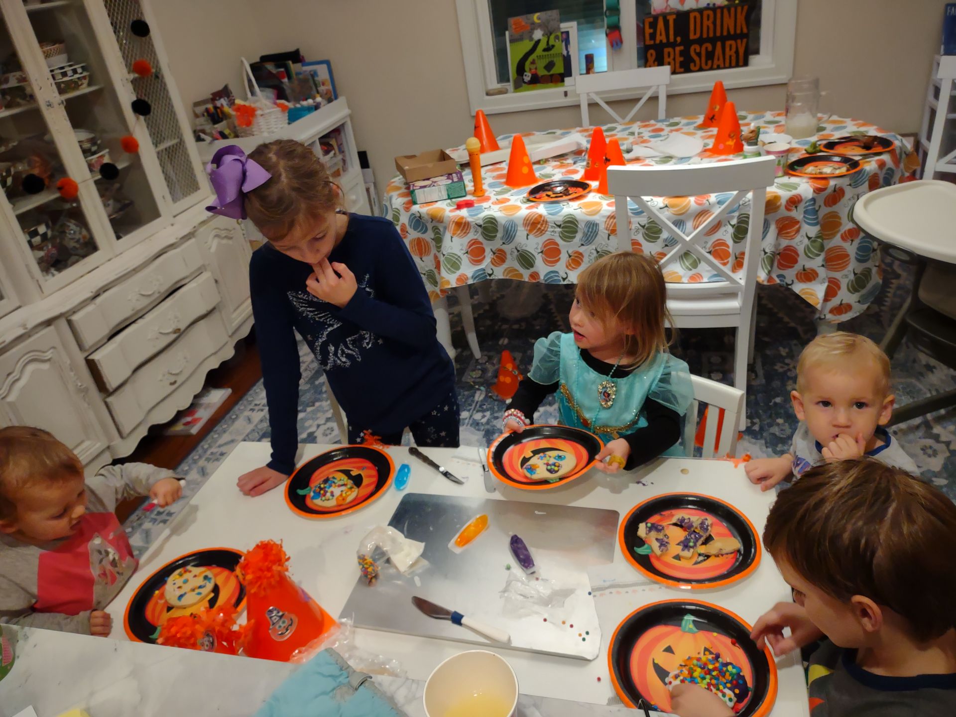The owners kids all decorating Halloween cookies.