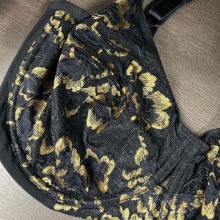 Black fabric with yellow floral pattern draped on a beige textured surface