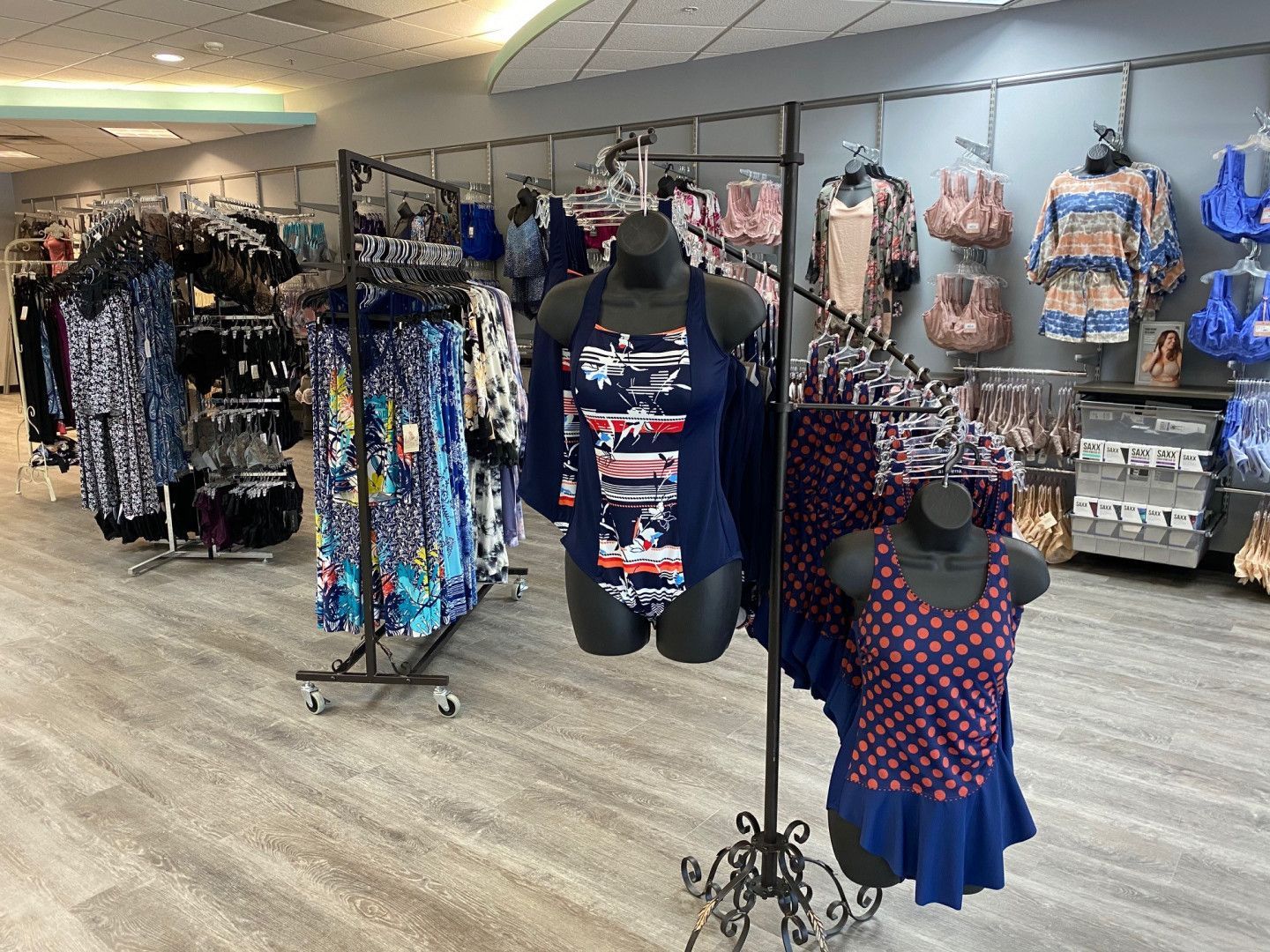 Clothing boutique with racks of colorful dresses and tops in a bright retail store interior