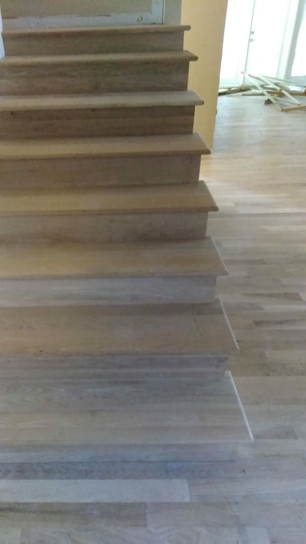 A close up of a wooden staircase with a wooden floor.