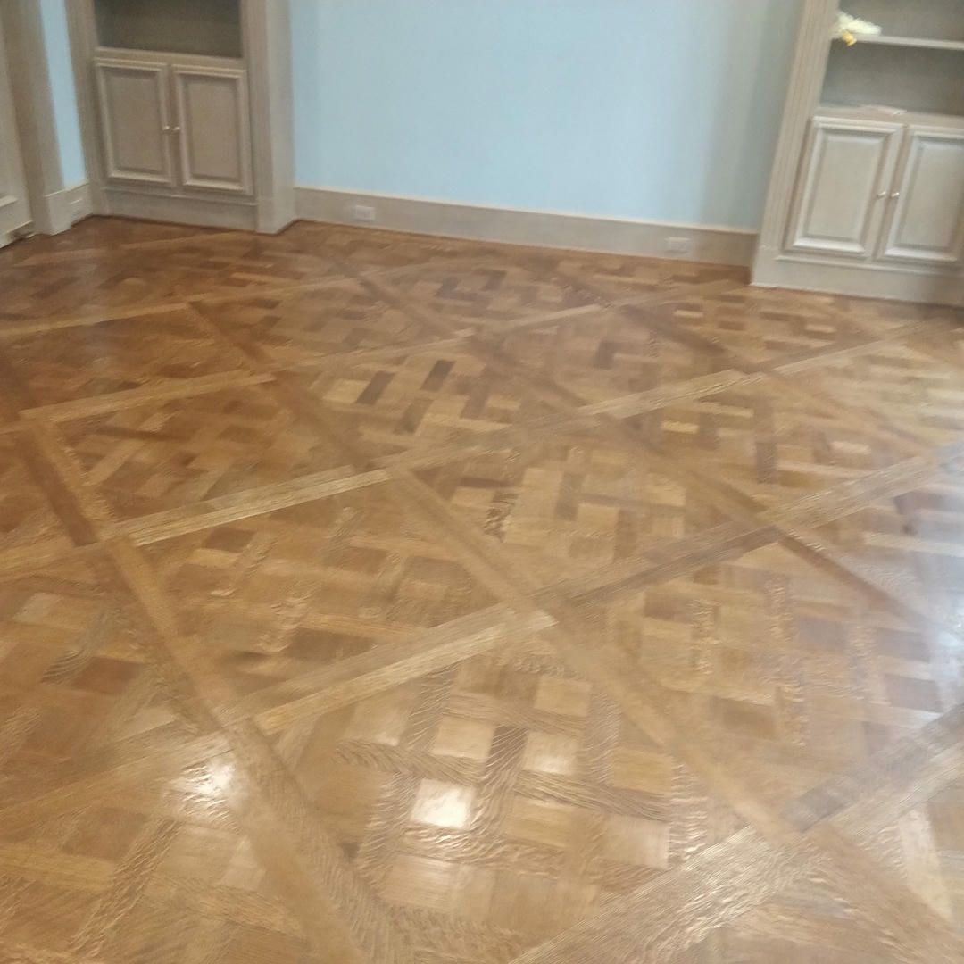 A wooden floor with a geometric pattern in a room.