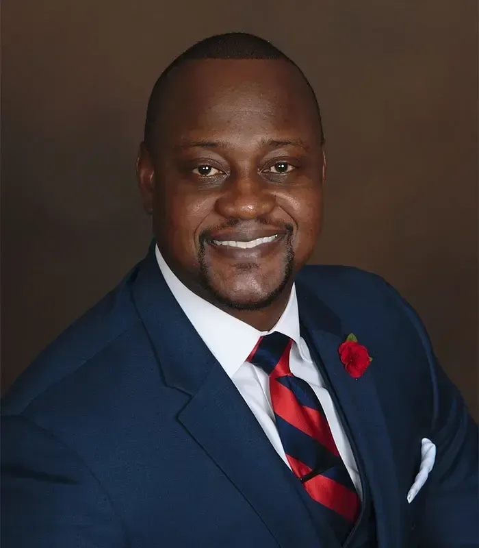 A man in a suit and tie is smiling for the camera