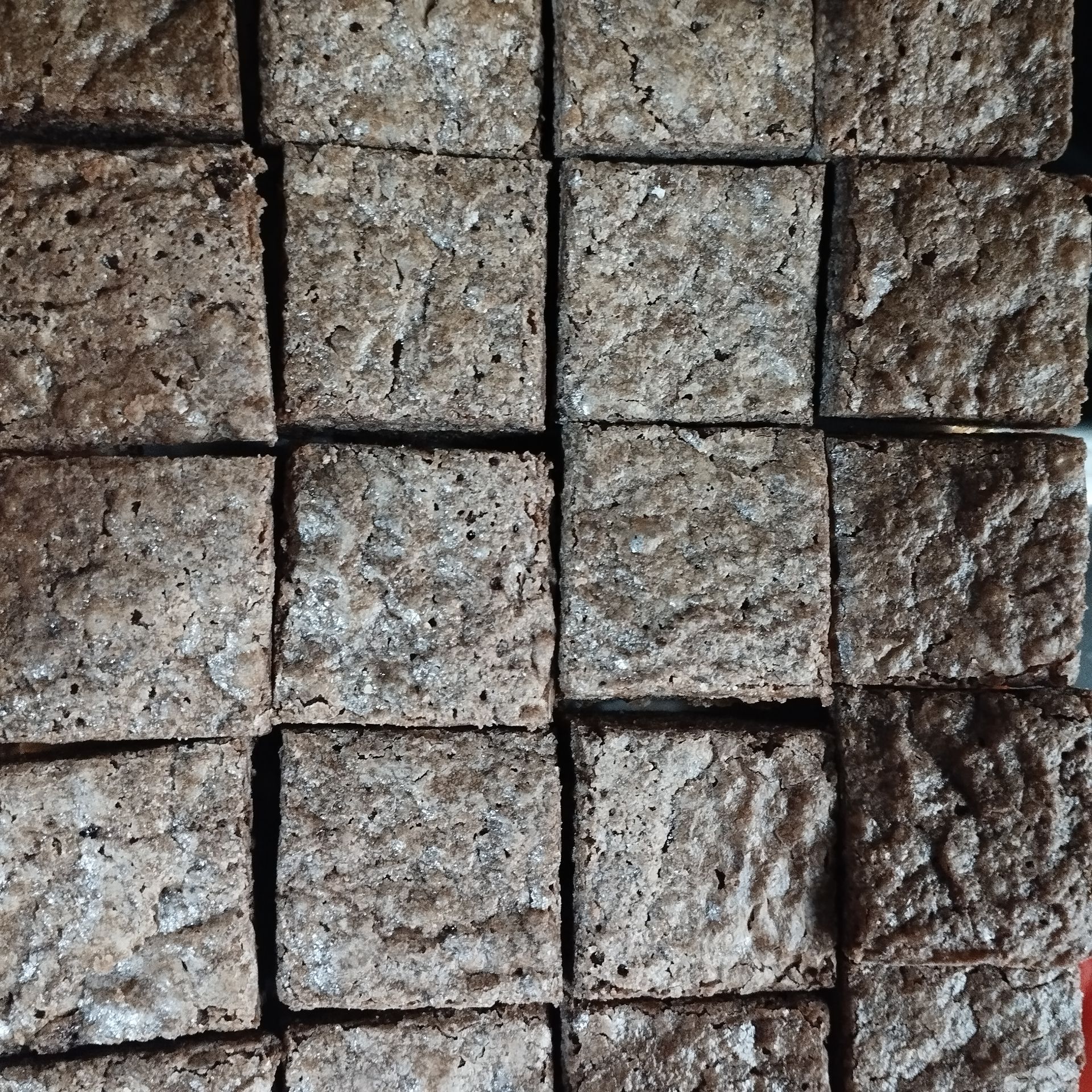 Primer plano de baldosas de piedra beige rugosa dispuestas en un patrón de cuadrícula.