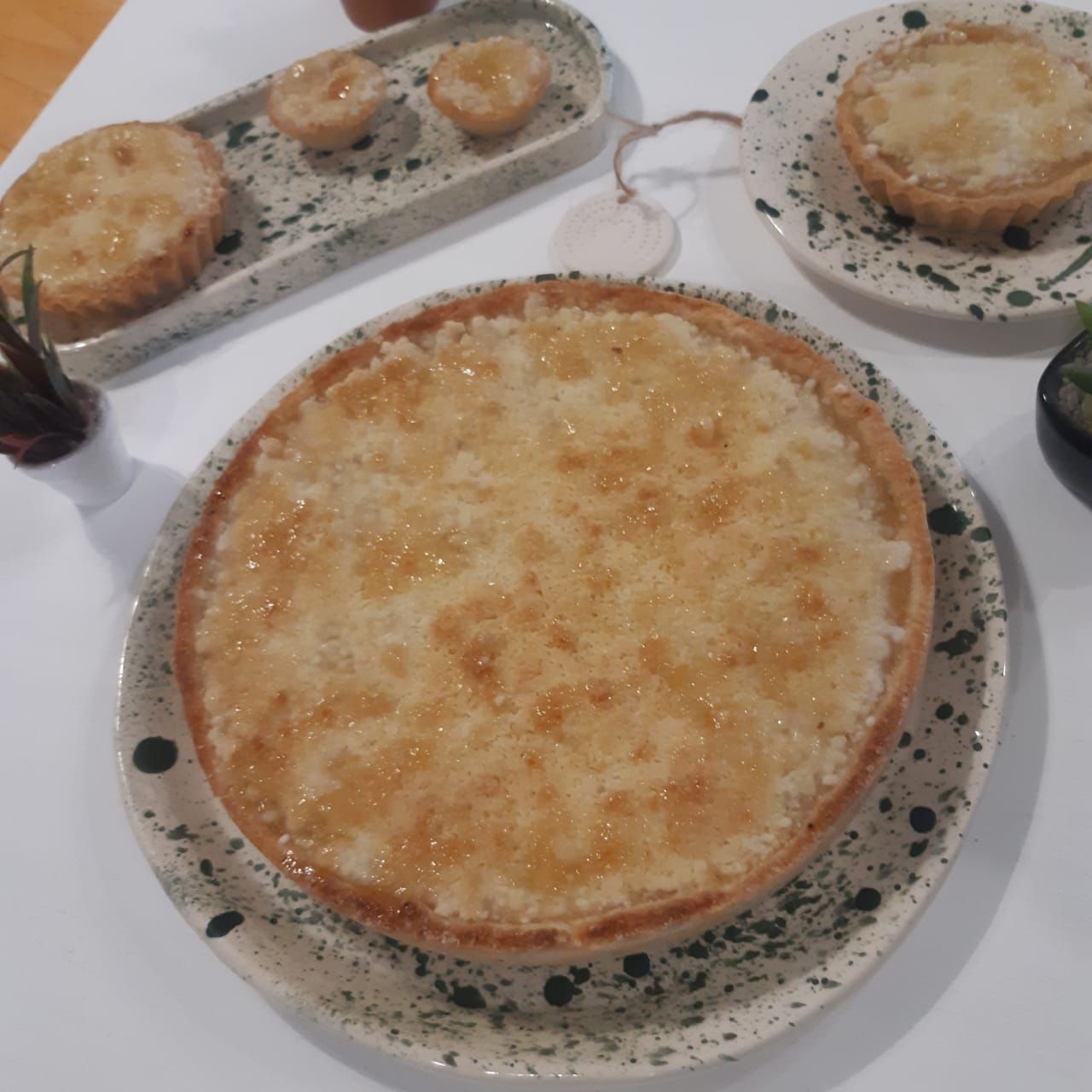 Tres platos horneados sobre una mesa, incluyendo una gran cazuela dorada en primer plano.