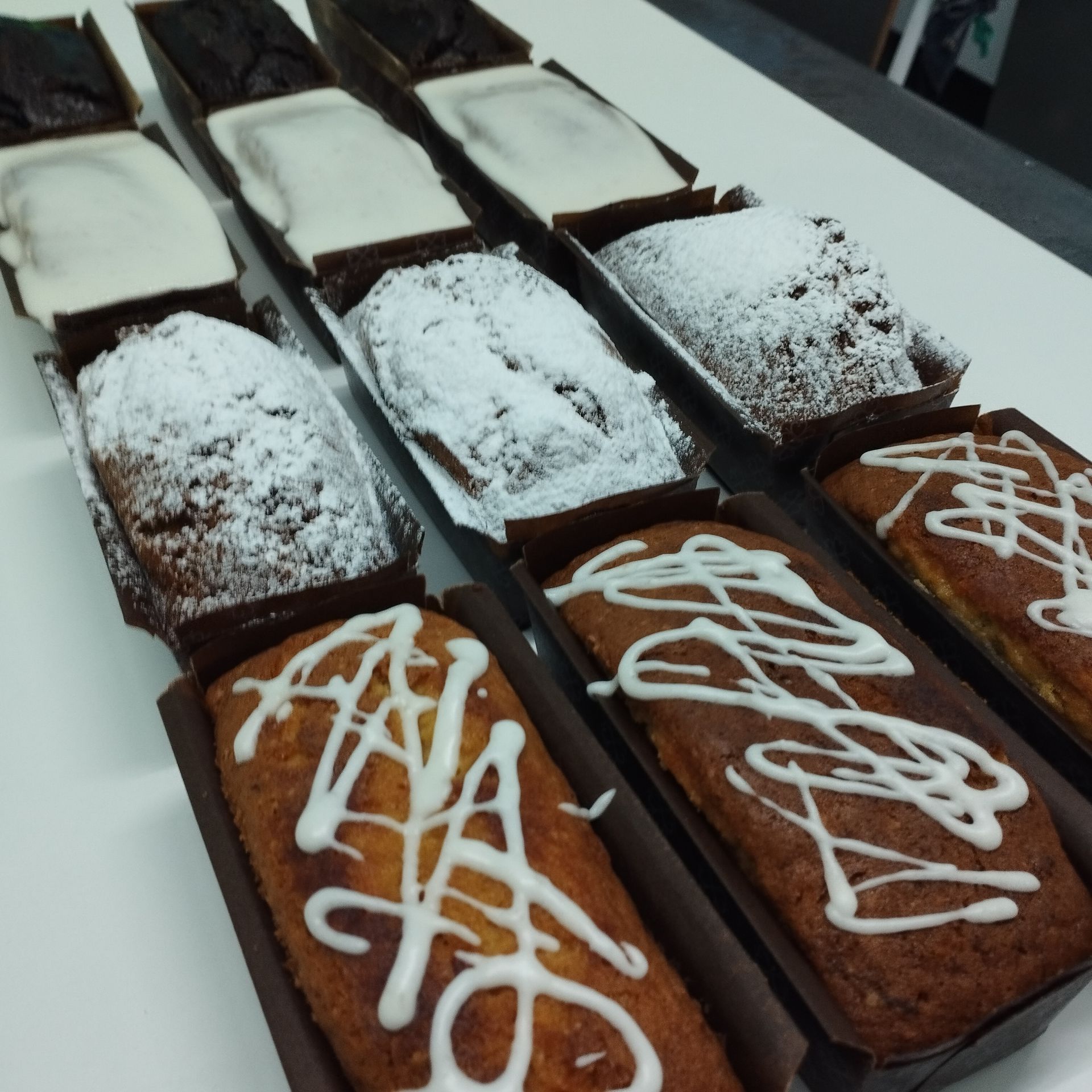 Bandeja de brownies de chocolate rectangulares cubiertos con glaseado blanco y azúcar glas.