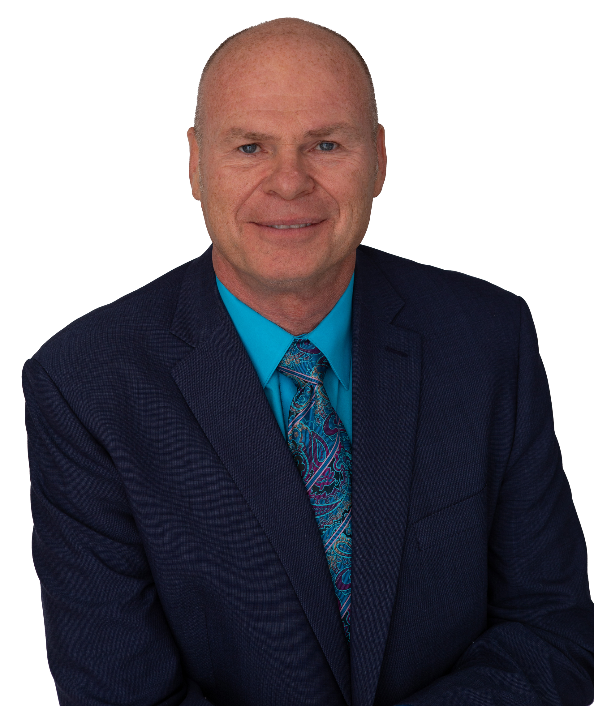 Jeff Cronk - Smiling man in a navy suit and blue patterned tie on a white background