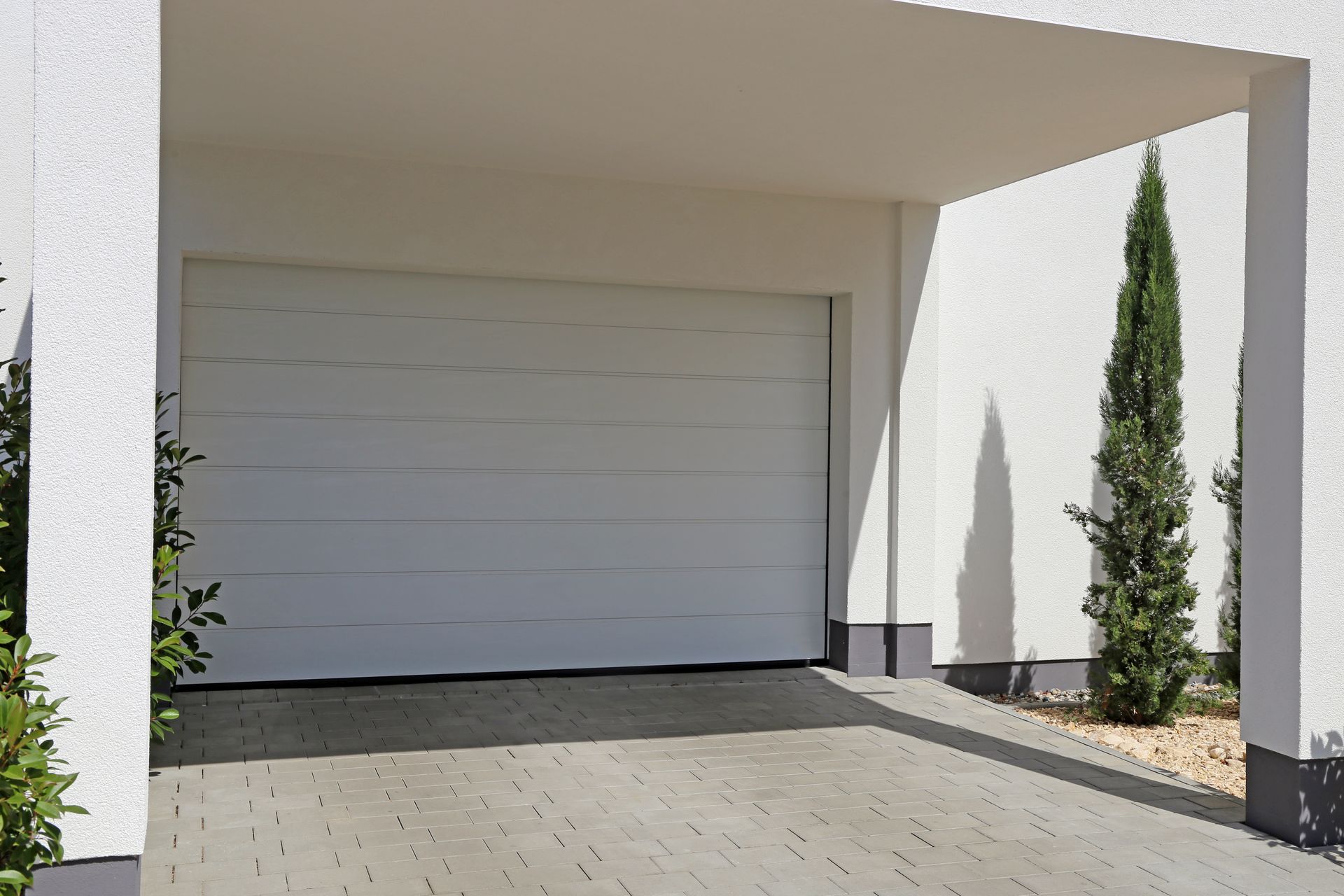 A person is opening a garage door with a remote control.