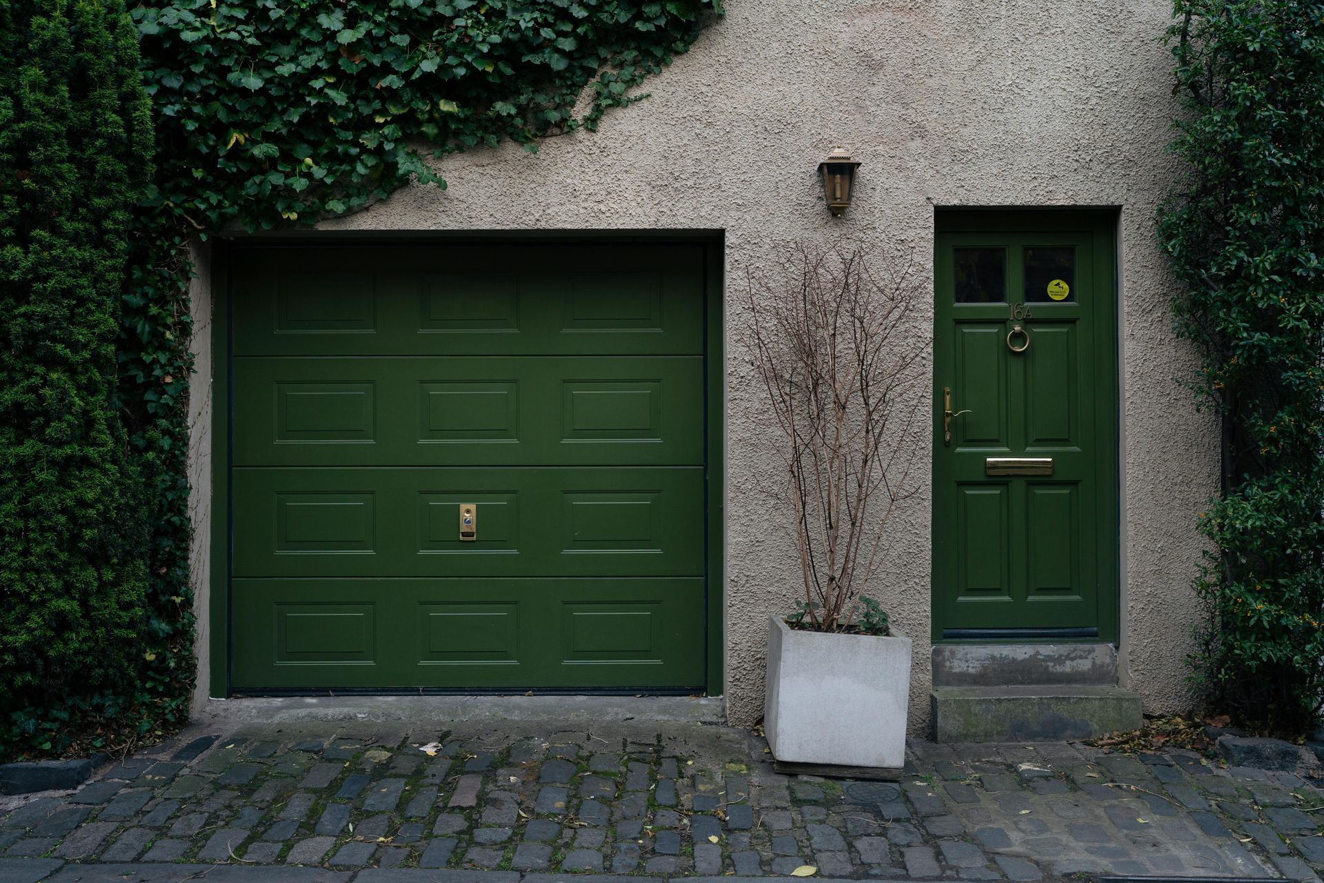 A person is opening a garage door with a remote control.