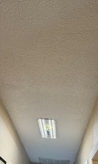 The ceiling of a hallway with a light on it.