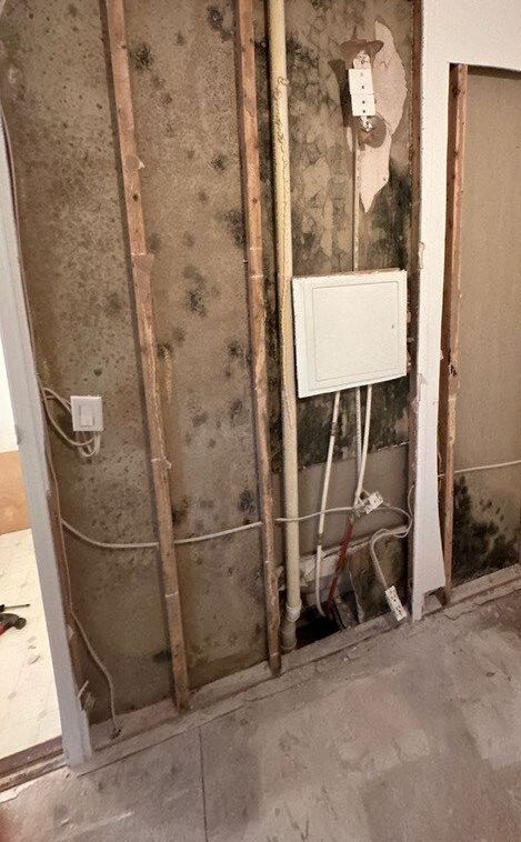A room with a dirty wall and a white box on it.