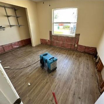 A room with a wooden floor and a window.