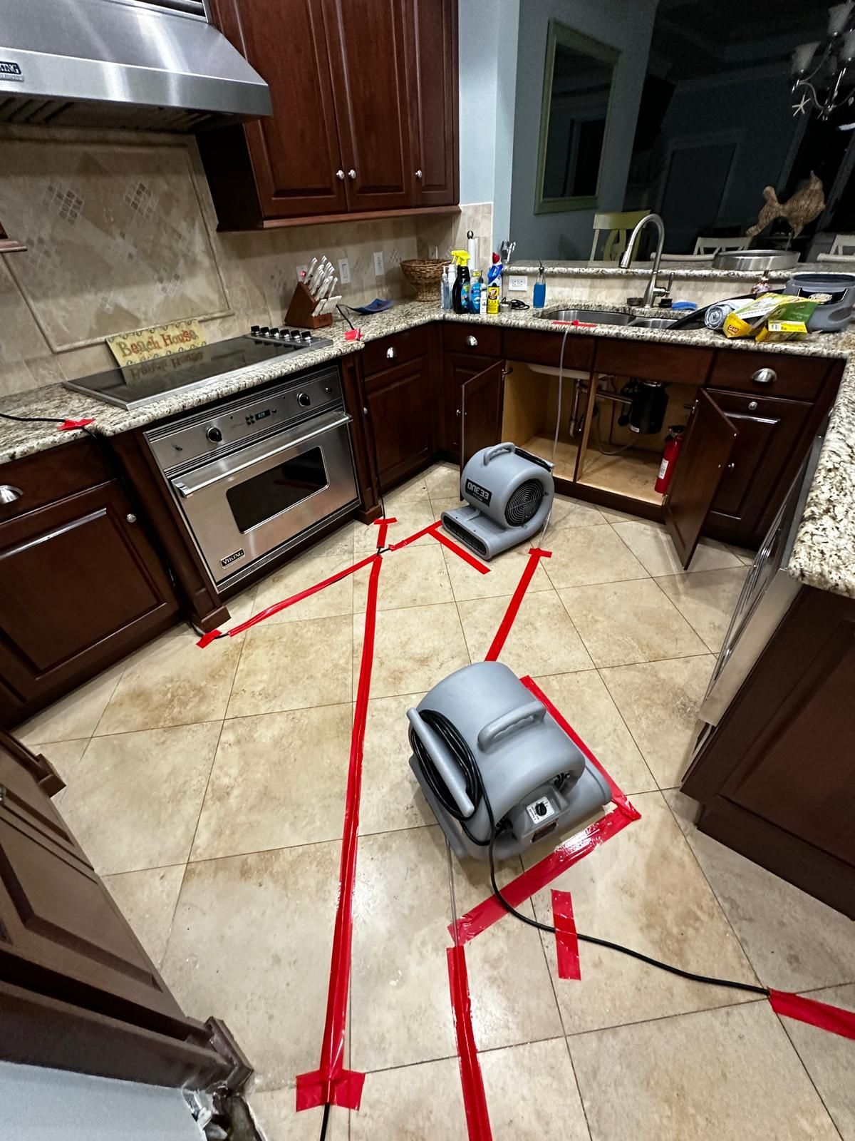 Two dryers are sitting on the floor of a kitchen.