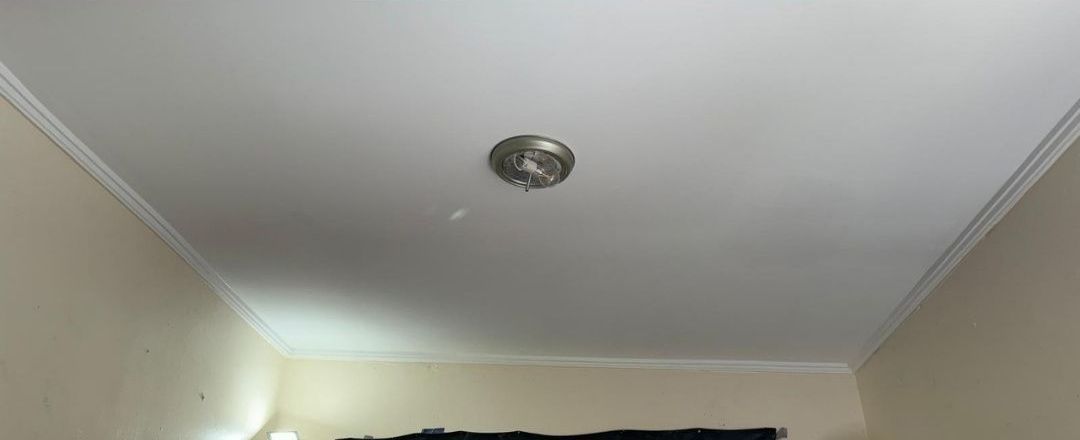 A ceiling fan is hanging from the ceiling of a room.