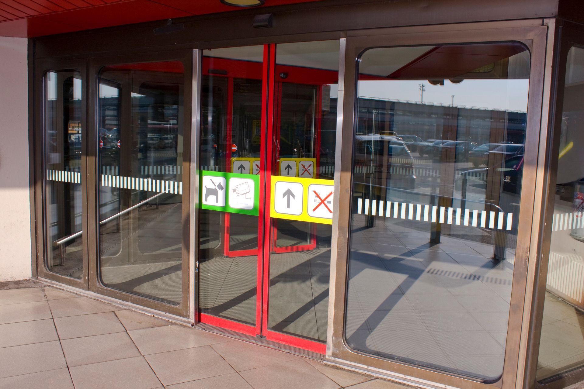 Closed airport sliding door on sunny day, representing storefront sliding glass door repairs. Closed airport sliding door on sunny day, representing storefront sliding glass door repairs.