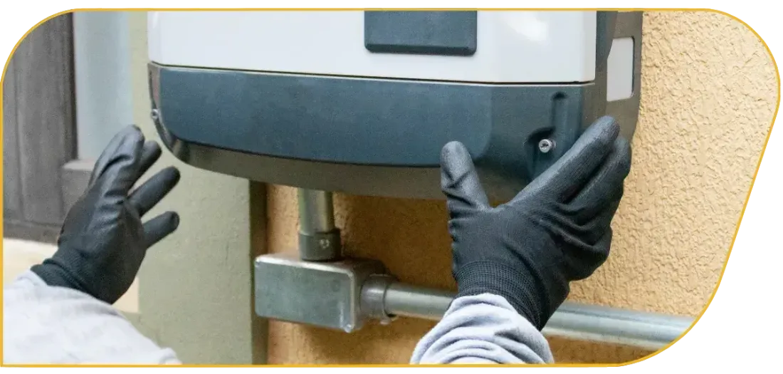 Gloved hands adjusting a wall-mounted device with a gray and black housing