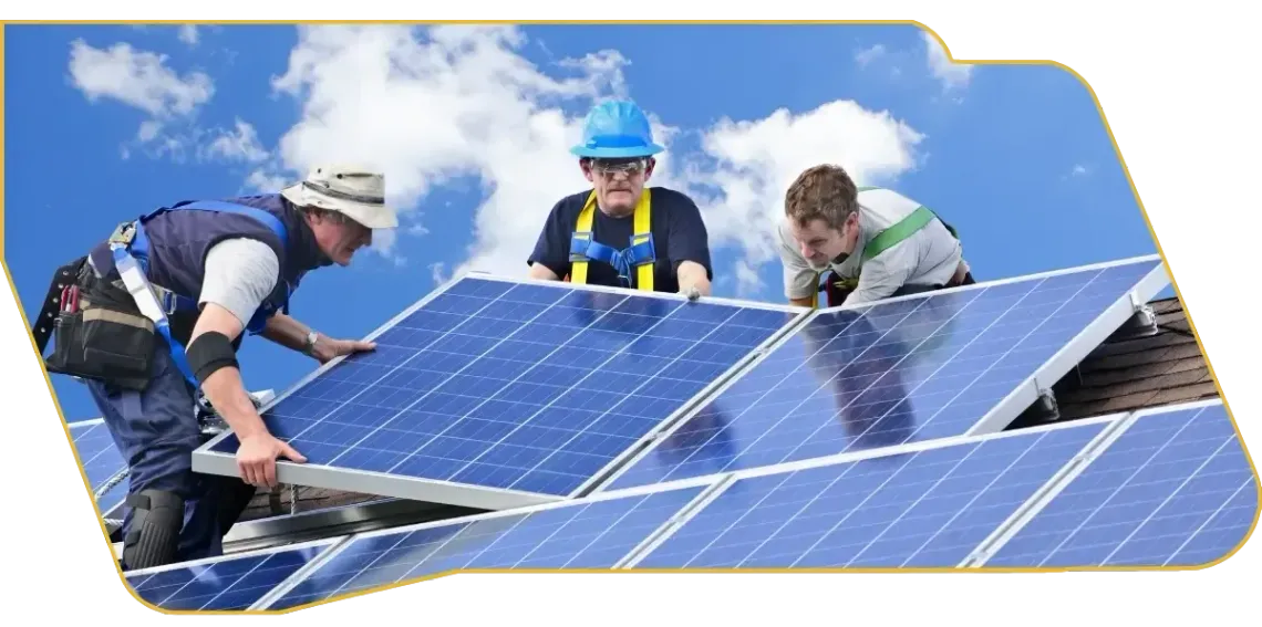 Workers installing blue solar panels on a rooftop under a clear sky