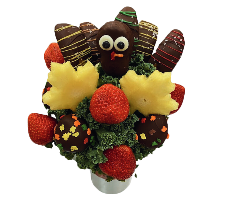 A skull shaped vase filled with strawberries and grapes