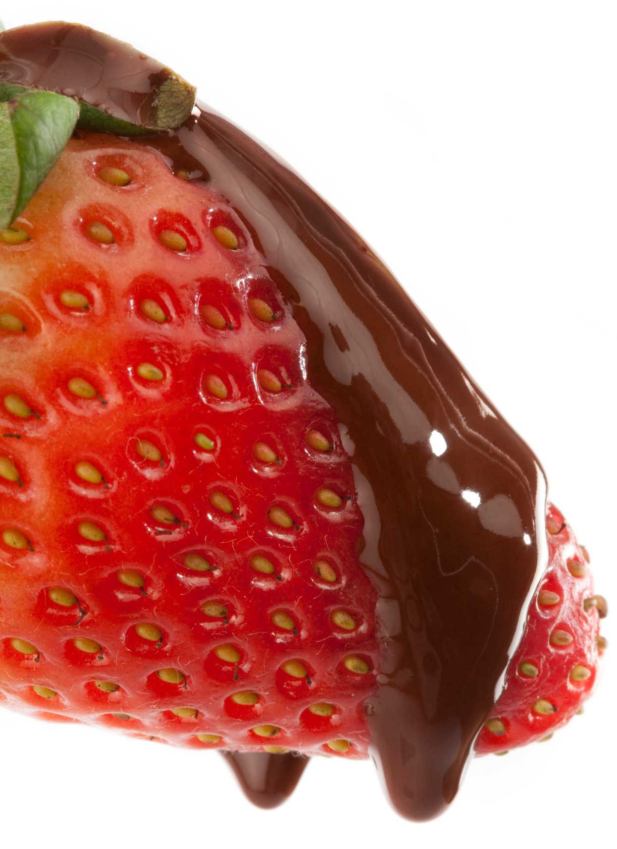 A strawberry covered in chocolate sauce on a white background