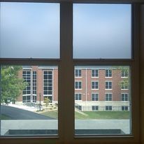 A view of a brick building through two windows.