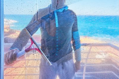 A man is cleaning a window with a squeegee.