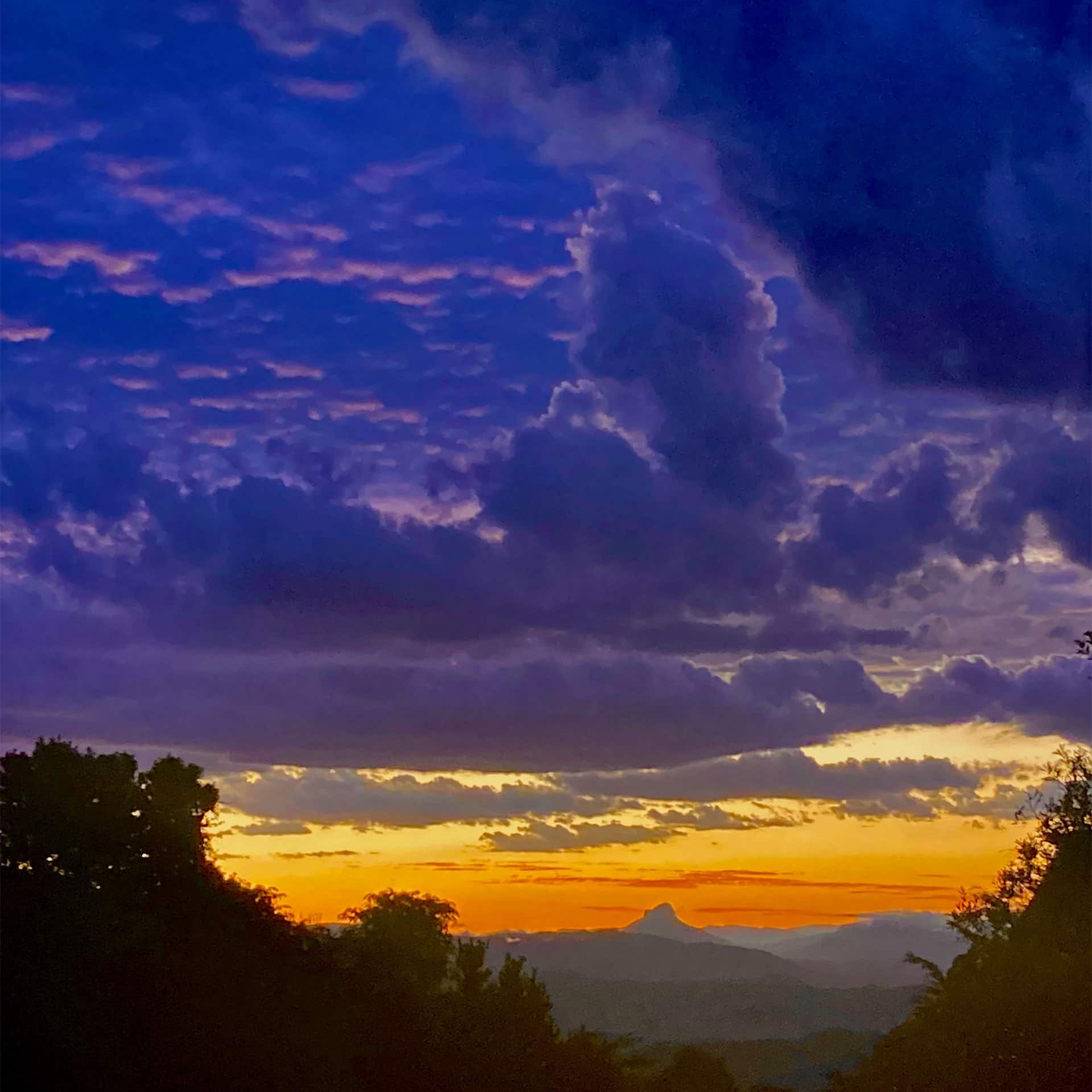 A Colourful Sunset Over A Mountain Range With Trees In The Foreground — My Energetic Craft In Morisset, NSW 